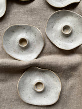 Load image into Gallery viewer, Bougeoirs en grès clair aux contours irréguliers et aux délicates touches gris-vert, disposés sur un tissu beige.