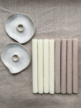 Load image into Gallery viewer, Deux bougeoirs en céramique claire et huit chandelles en cire d’abeille gaufrée, ivoire et beige, disposés sur du lin.