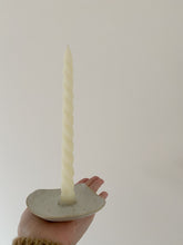 Load image into Gallery viewer, Bougeoir en grès fait main, tenu dans une main avec une longue chandelle torsadée ivoire.
