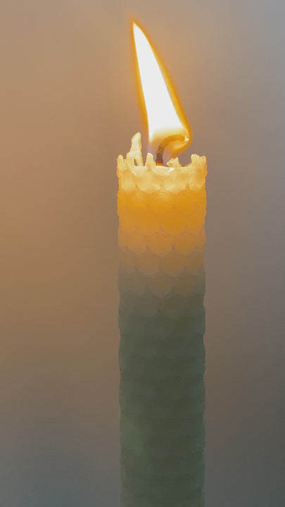 Une bougie crème en cire d'abeille allumée. La beauté en toute simplicité.